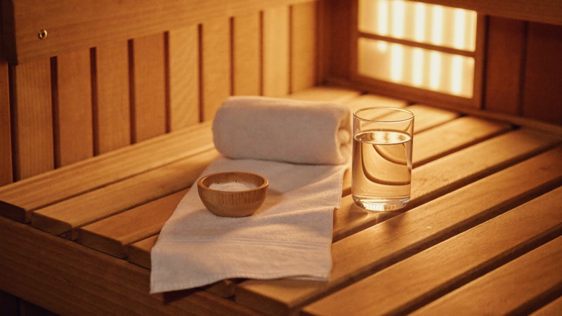 Serviette et verre d’eau sur le banc d’un sauna infrarouge